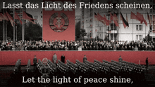 a large crowd of people are gathered in front of a large red banner that says ddr let the light of peace shine