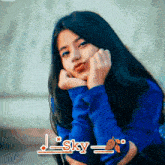 a girl in a blue sweater with the name sky on the bottom right