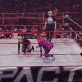 a woman in a purple outfit is kneeling down in a wrestling ring