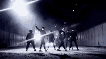 a group of men are dancing in front of a fence at night .