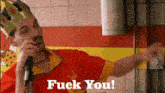 a man wearing a crown is talking into a microphone with the words " fuck you " on the bottom