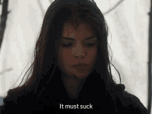 a close up of a woman 's face with the words `` it must suck '' written above her .