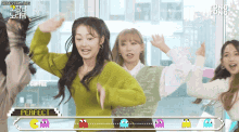 a group of girls are dancing in front of a perfect sign