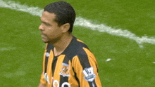 a soccer player wearing a yellow and black jersey with a lion on it