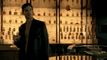 a man standing in front of a bar holding a drink