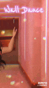 a woman is dancing in a hallway under a neon sign that says " wall dance "