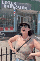a woman standing in front of lotus hair salon