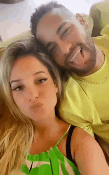 a man and a woman are posing for a picture with the man sticking his tongue out .