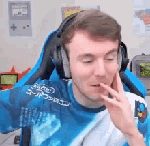 a man wearing headphones and a tie dye shirt is sitting in a blue chair .