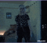 a person is dancing in a dark room with a xrecorder watermark on the bottom
