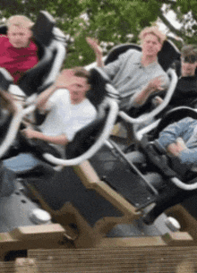 a group of young men are riding a roller coaster