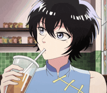 a girl drinking from a cup with a straw and the letter h on her shirt