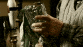 a man in a sweater is holding a glass