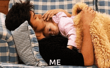 a man is laying on a couch holding a baby and the word me is on the bottom
