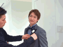 a man in a tuxedo has a flower in his pocket