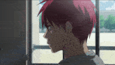 a boy with red hair looks out a window