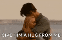 a man is holding a woman in his arms and saying give him a hug from me .