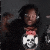 a man wearing headphones and a black shirt with a skull on it is dancing .