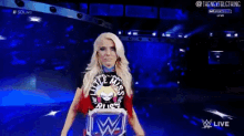 a female wrestler named alexa bliss is standing on a blue stage