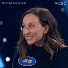 a woman wearing a name tag that says sarah is smiling