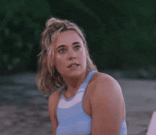a woman in a blue tank top is talking to another woman