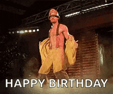a shirtless man in a fireman 's uniform is dancing on a stage and says `` happy birthday '' .
