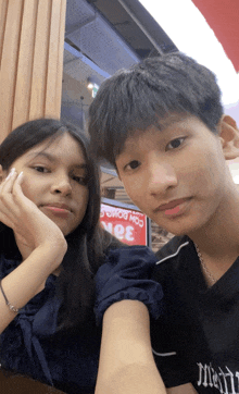 a boy and a girl are posing for a picture in front of a sign that says ' moo '