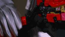 a close up of a person 's hand holding a red object