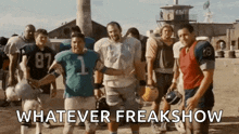 a group of football players are standing next to each other in a field with the words `` whatever freakshow '' above them .