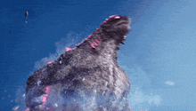 a giant monster with a blue sky in the background is being attacked by a balloon