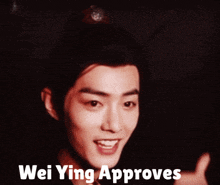 a young man giving a thumbs up with wei ying approves written below him