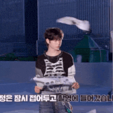 a young man is holding a newspaper with foreign writing on it ..