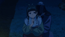 a man and a girl are sitting on the grass at night