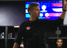 a man wearing a black jacket with a canadian flag patch on it