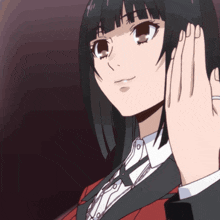 a girl in a suit and tie covering her ears with her hands