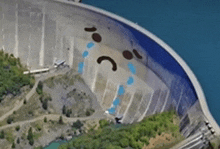 an aerial view of a dam with a sad face drawn on the side