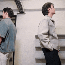 two men standing next to each other with one wearing a jacket that says ' denim ' on it