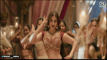 a woman in a red top is dancing in front of a crowd with the words pranay varma on the bottom