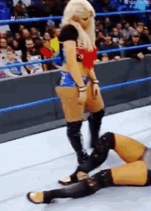 a woman in a wrestling ring is kicking another woman