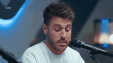 a man singing into a microphone with the word rtve on the bottom