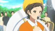 a girl playing a trombone with a yellow hat on