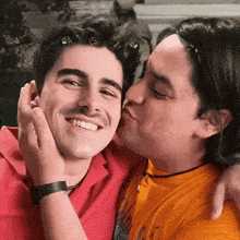 a man kissing another man on the cheek while wearing a watch that says casio
