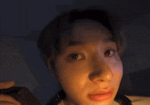 a close up of a person 's face in a dark room with a light shining on it .