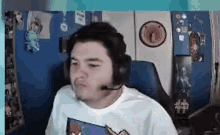 a man wearing headphones and a microphone is sitting in a chair in front of a computer screen .