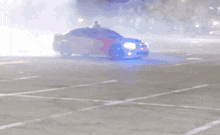 a red car is driving down a street with smoke coming out of the hood
