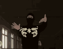 a person wearing a black hoodie with a skeleton design on it