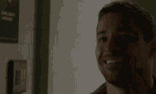 a man is smiling in front of a wall that has a sign on it that says " only ladies allowed "