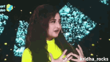 a woman in a neon yellow top is smiling and the name kridha_rocks is on the bottom right
