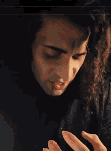 a close up of a person 's face with a hand reaching out