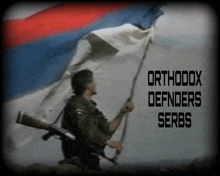 a man holding a flag with the words orthodox defenders serbs on the bottom right